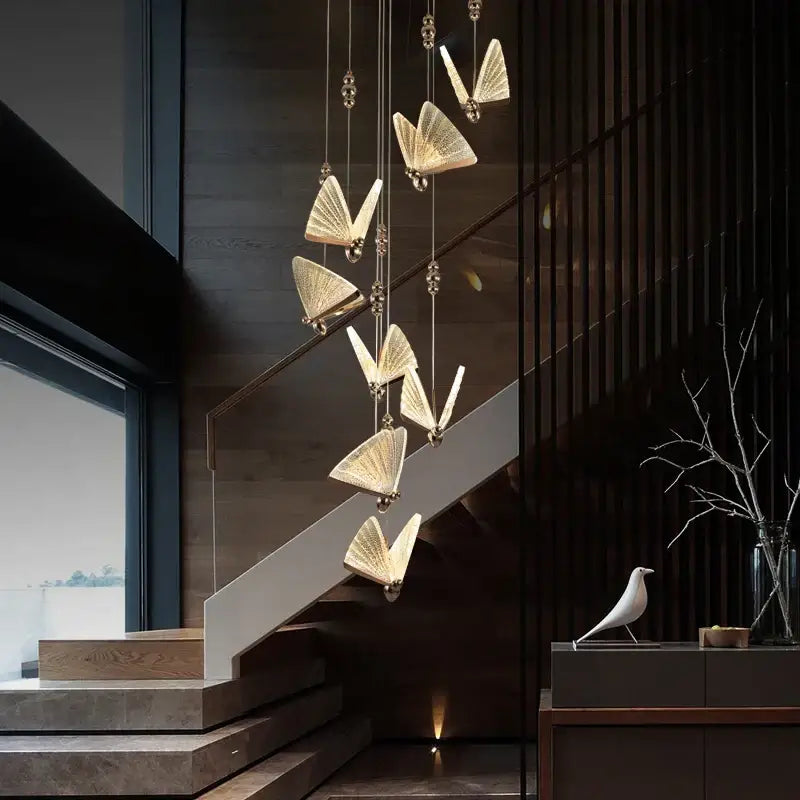 A modern golden acrylic butterfly chandelier ceiling lamp with multiple light fixtures suspended by slender chains