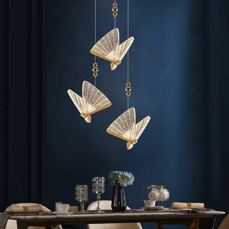 Three elegant gold-toned acrylic butterfly chandelier ceiling lamps with intricate mesh detail for indoor lighting
