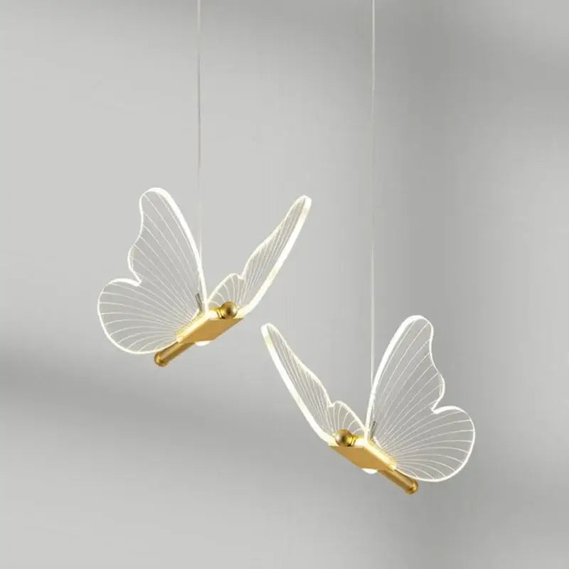 Two elegant translucent white acrylic butterfly led pendant lights with gold-toned bodies by decorbites