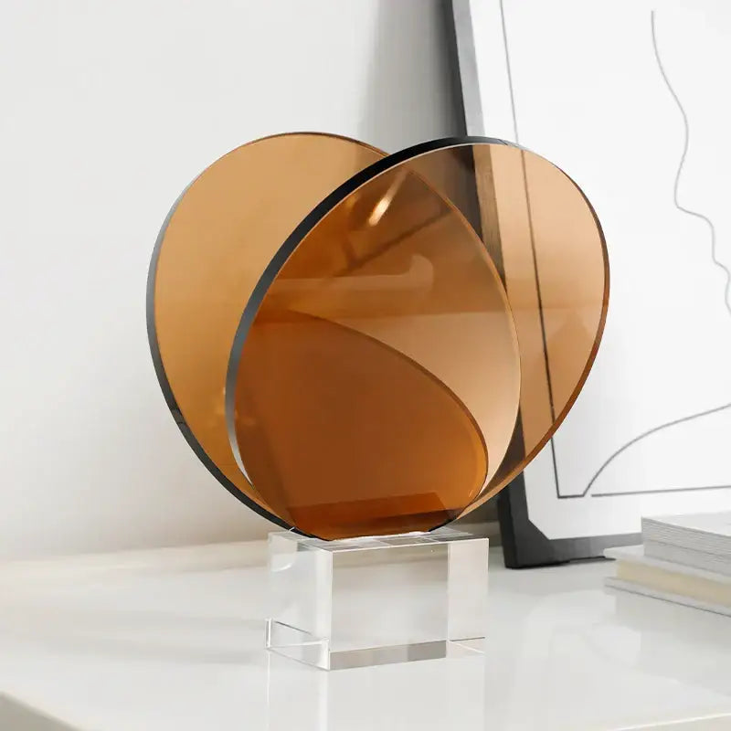 Amber-colored acrylic crystal bookshelf magazine rack with translucent overlapping spiral discs on a clear base