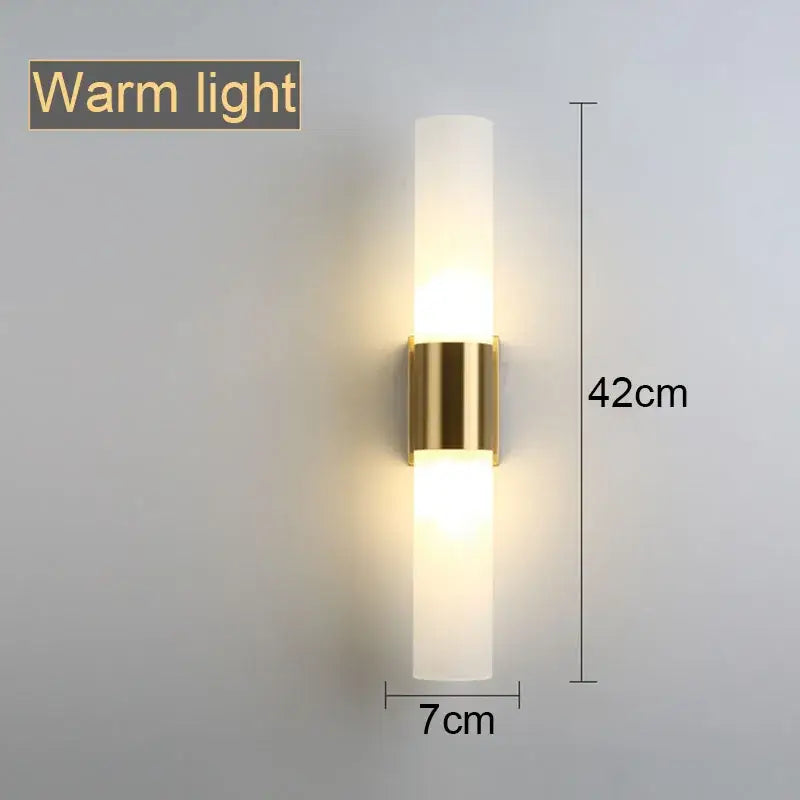 DecorBites™ acrylic cylinder wall lamp with sleek gold metal base and frosted glass emitting warm LED light for living room
