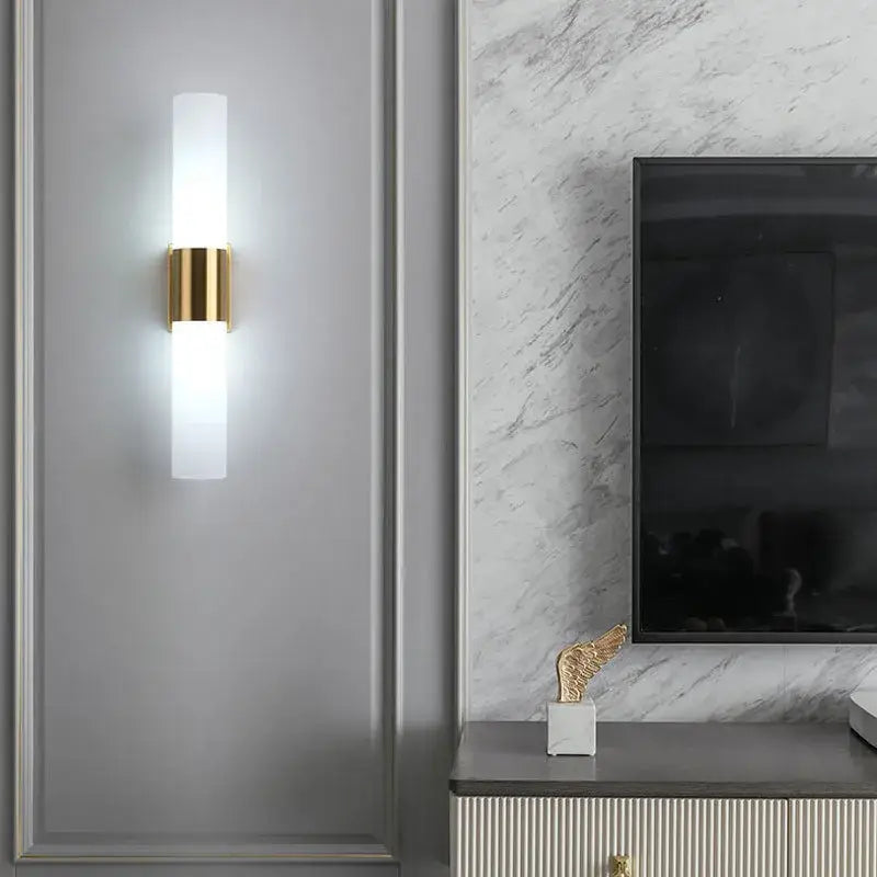 Modern DecorBites™ wall lamp with frosted acrylic cylinder and polished gold metal accents for bedroom and living room