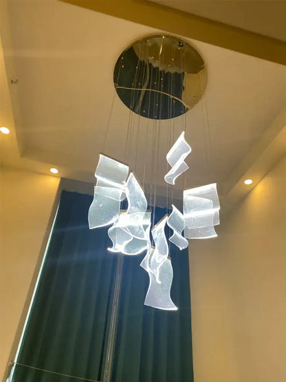 Modern white acrylic deluxe staircase chandelier with flowing sculptural pieces and gold-toned circular mount