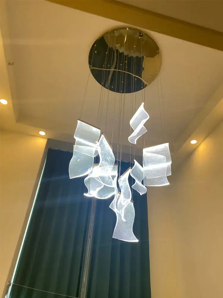 Modern white acrylic deluxe staircase chandelier with flowing sculptural pieces and gold-toned circular mount