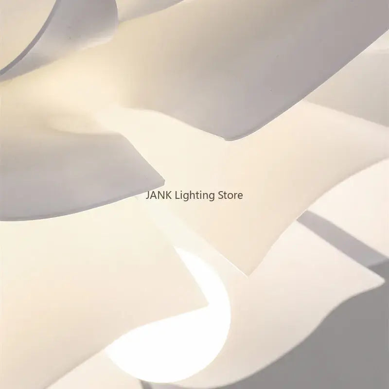 A modern white acrylic flower chandelier pendant light with layered petal-like shades emitting a soft glow
