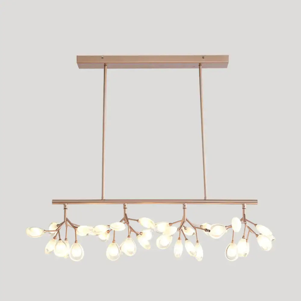 Modern rose gold acrylic island lighting fixture with delicate branch-like arms and teardrop glass bulbs for dining rooms