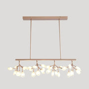 Modern rose gold acrylic island lighting fixture with delicate branch-like arms and teardrop glass bulbs for dining rooms