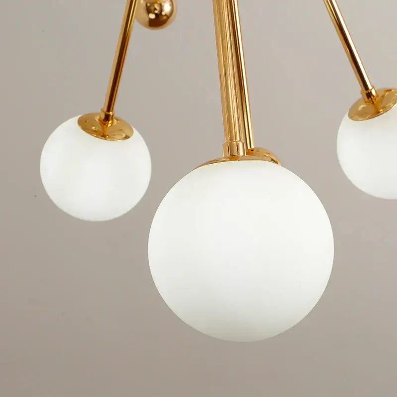 Gold-toned decorbites acrylic molecule chandelier with three frosted white glass globes for dining room lighting