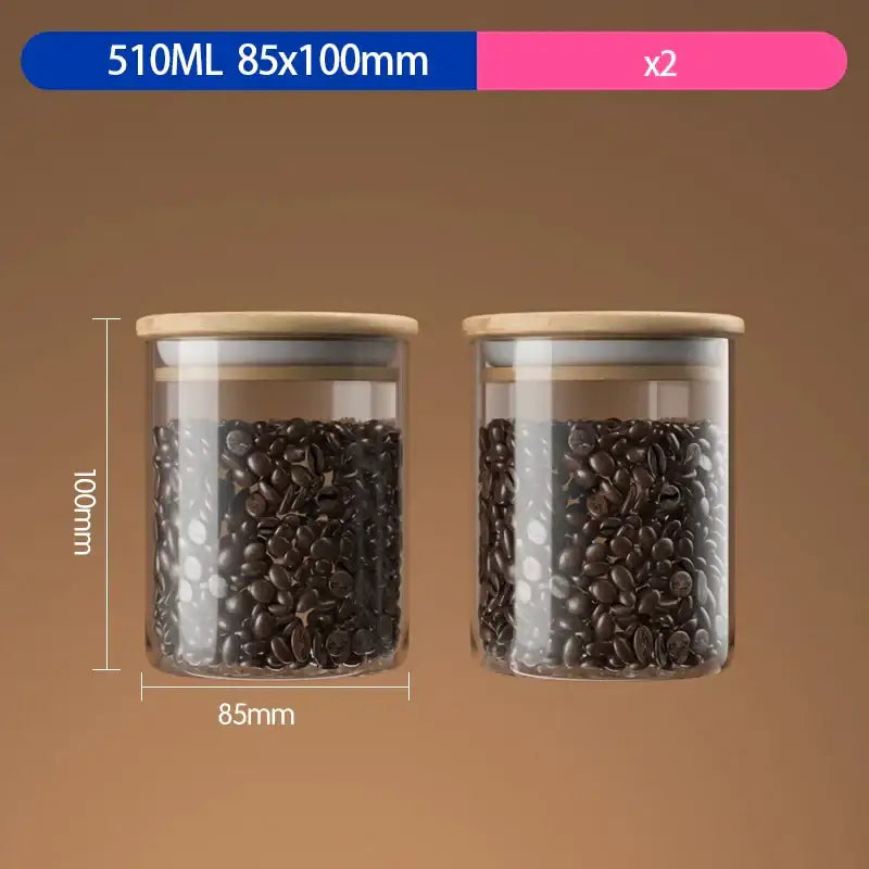 Two clear airtight glass coffee bean storage jars with bamboo lids holding dark roasted beans for kitchen preservation