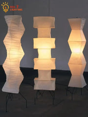 Three warm glowing decorbites akari japanese rice paper floor lamps with geometric and organic shapes for living room
