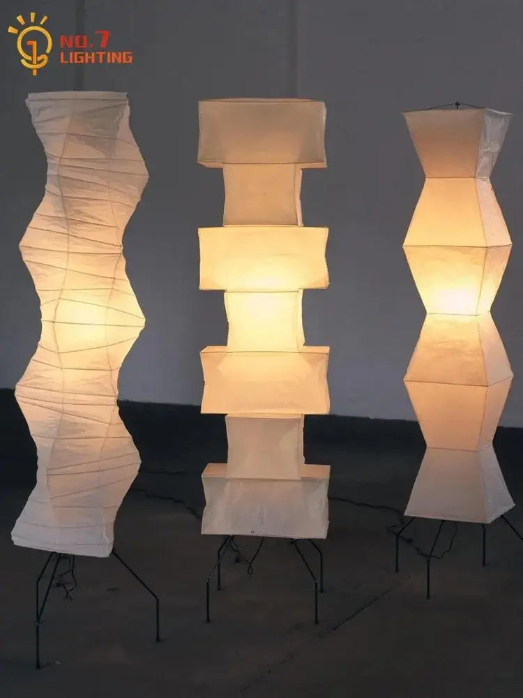 Three warm glowing decorbites akari japanese rice paper floor lamps with geometric and organic shapes for living room