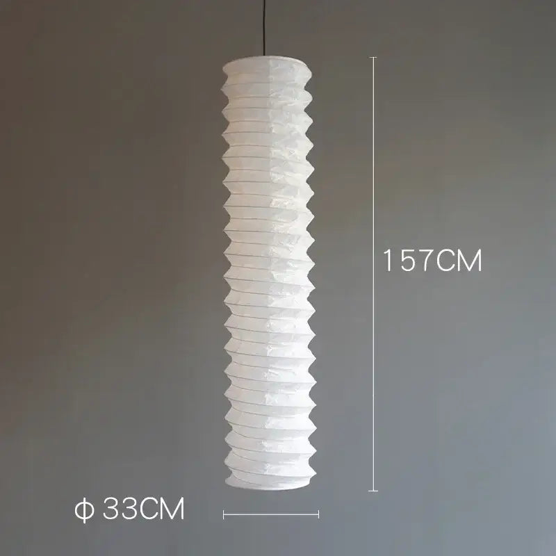 A tall white rice paper pendant light with a ribbed akari noguchi design hanging for home décor use