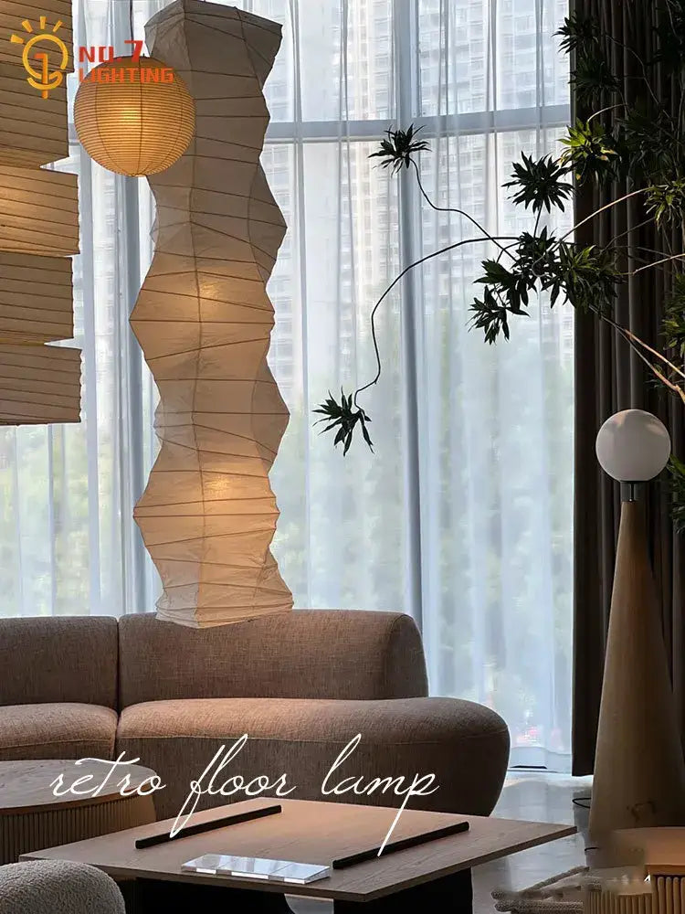 Tall sculptural akari noguchi floor lamp with warm glow and layered rice paper construction for living room decor