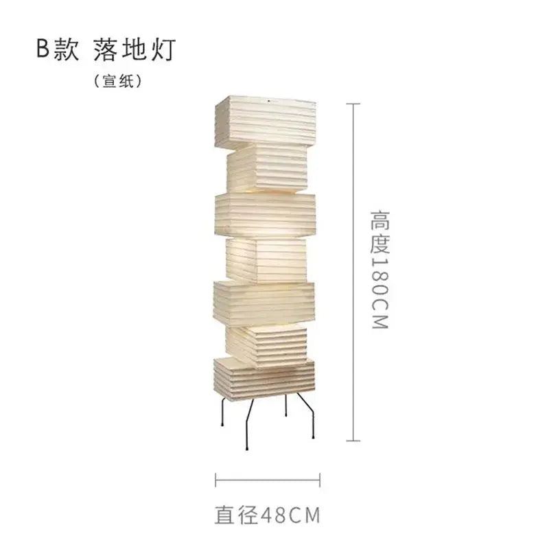 A tall off-white akari noguchi floor lamp with stacked rice paper sections and minimalist metal base for living room lighting