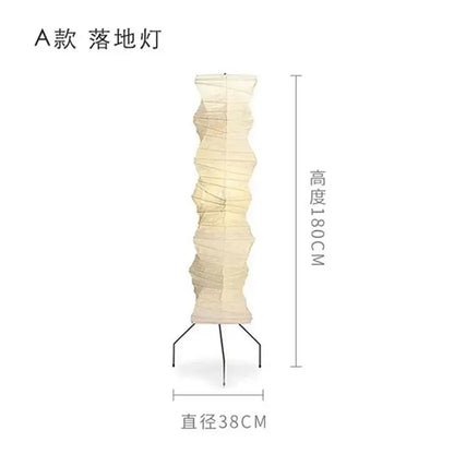 Cream-colored akari noguchi floor lamp with accordion folded rice paper shade and black metal tripod base for living room