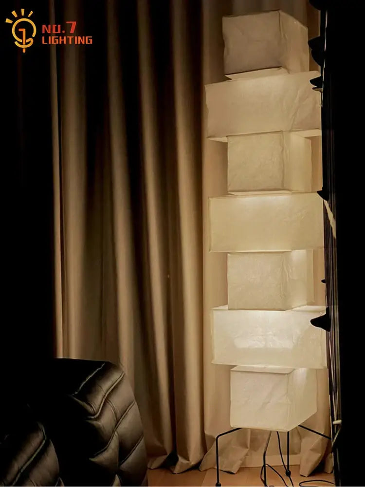A modern akari noguchi floor lamp with tiered white rice paper shades and black metal base for living room decor