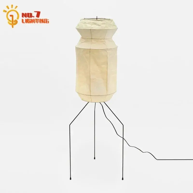 Cream-colored akari noguchi rice paper table lamp with geometric design and black metal tripod base for living room use