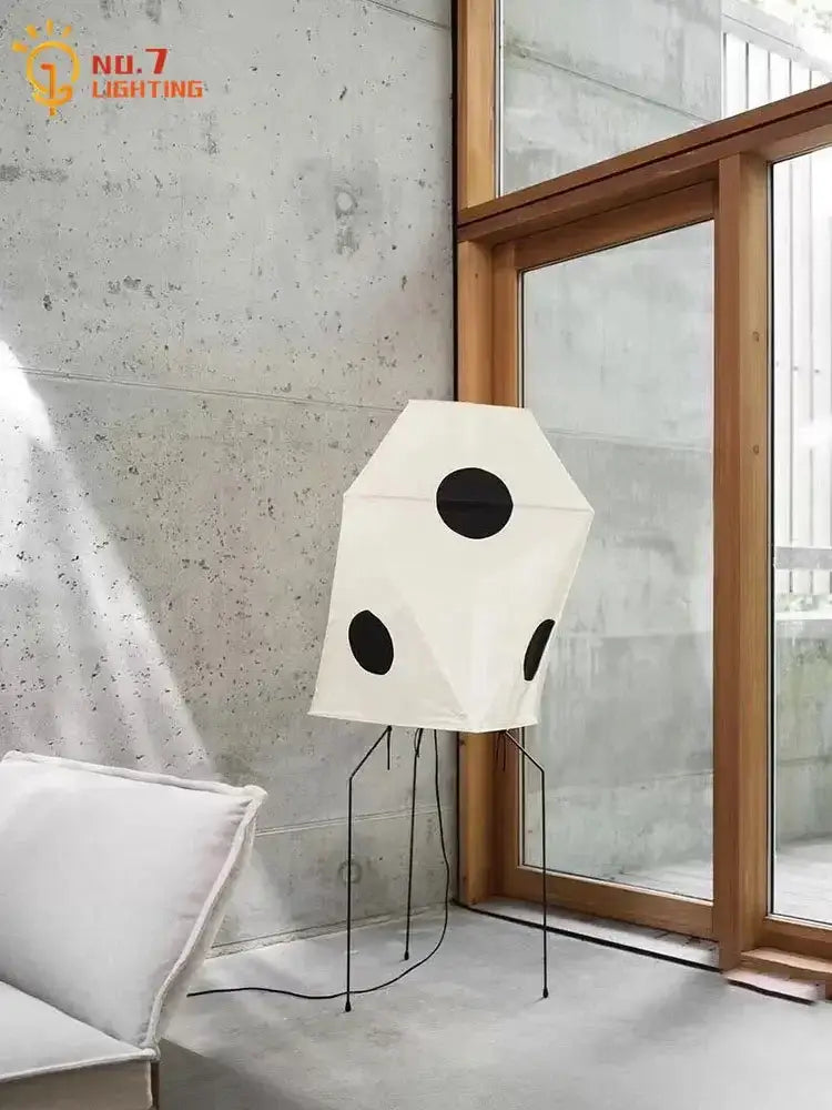 White geometric decorbites akari rice paper floor light with black accents and slender metal legs in minimalist design