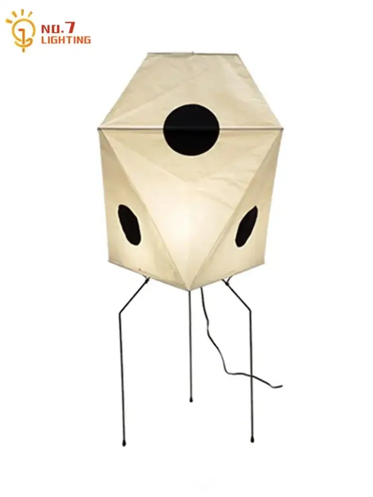 Cream-colored akari rice paper floor lamp with black circular cutouts and slender metal legs for elegant lighting