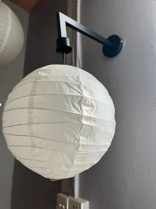 White spherical akari rice paper pendant lamp with black metal wall mount for living room or bedroom lighting