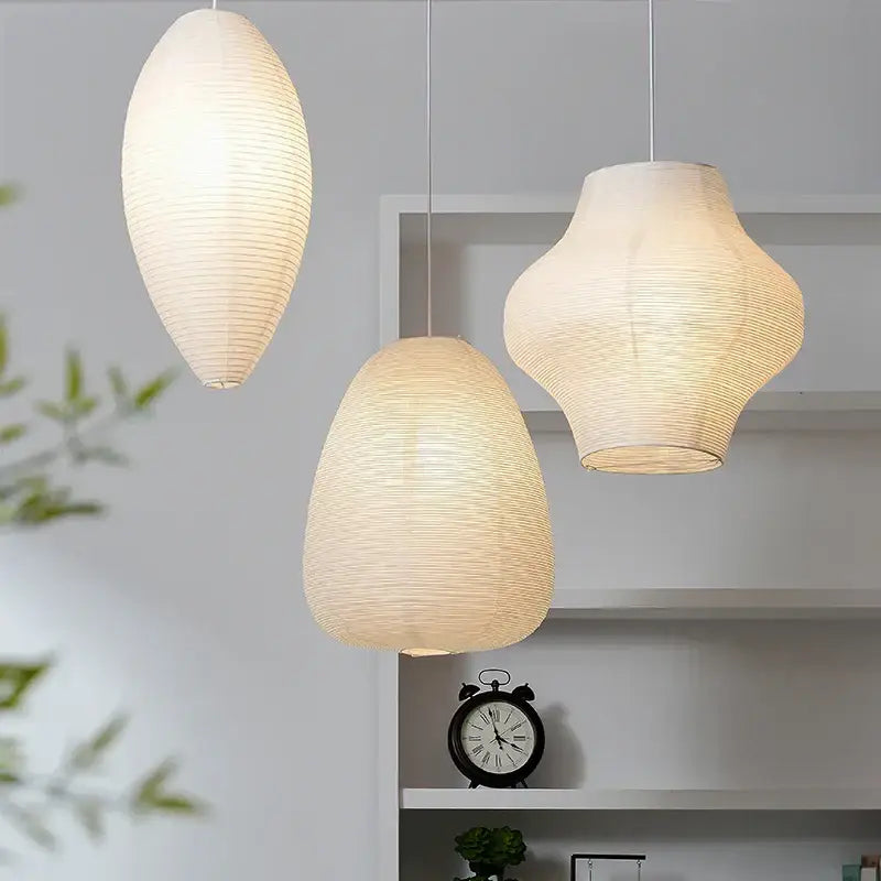 Three elegant off-white akari rice paper pendant lamps with ribbed textures and soft glow for living room lighting