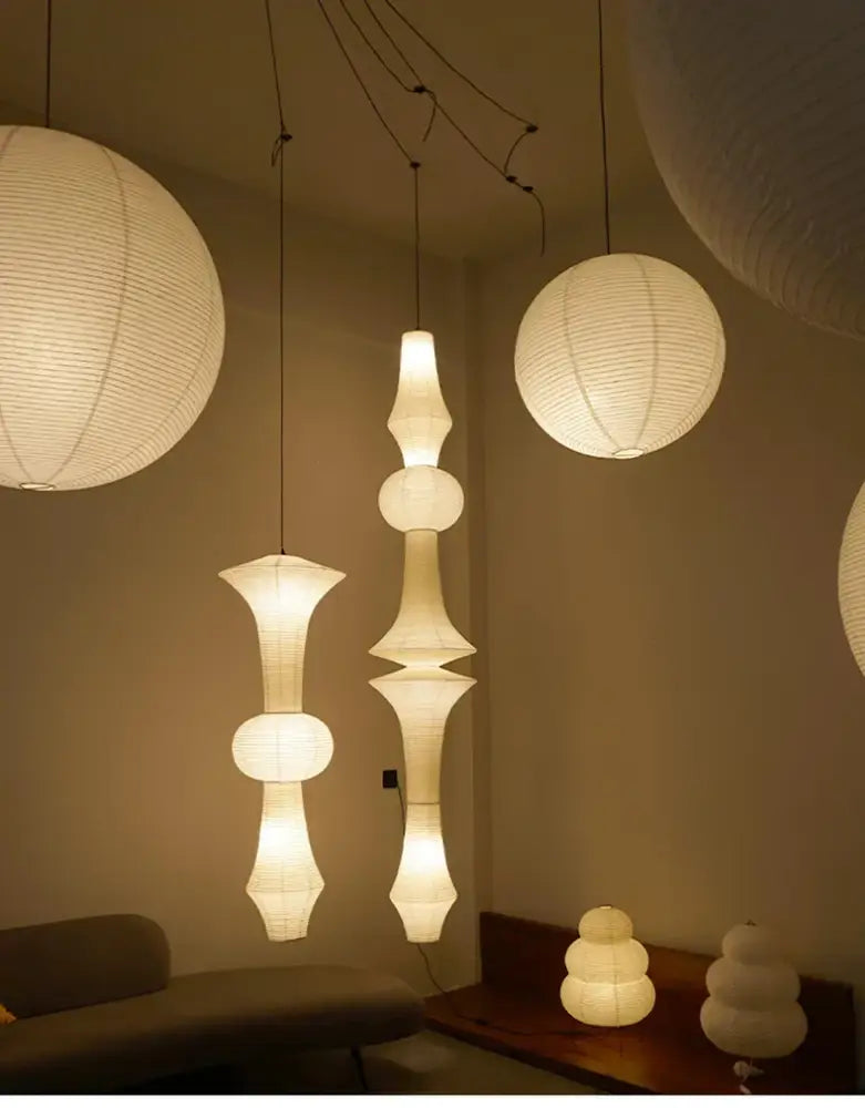 White DecorBites akari rice paper pendant lamps with textured segmented design hang from ceiling in various sizes