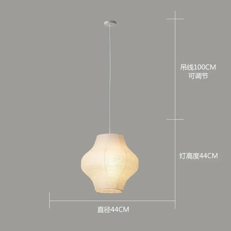 A warm glowing decorbites akari rice paper pendant lamp with textured off-white shade and slender white cord