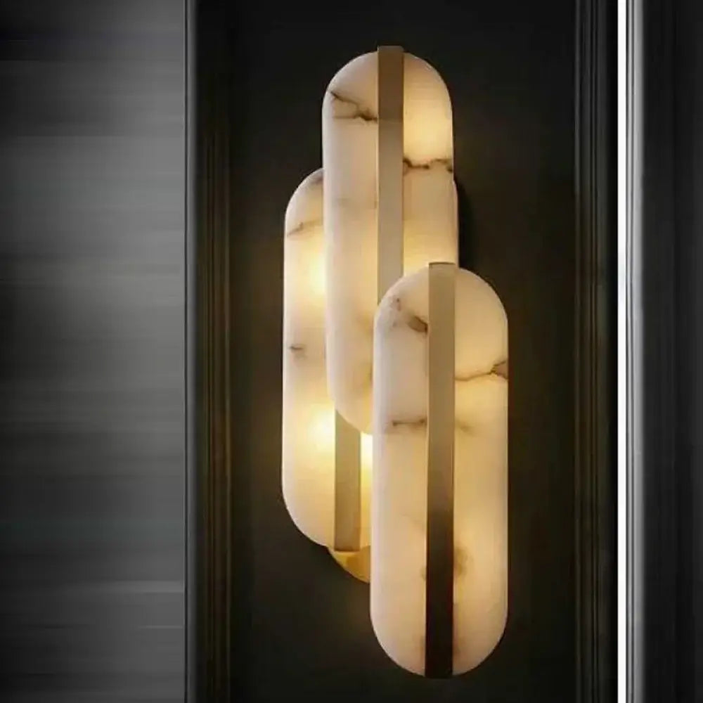 Modern DecorBites wall lamp with three stacked alabaster oval marble panels and brass bar accents for indoor lighting