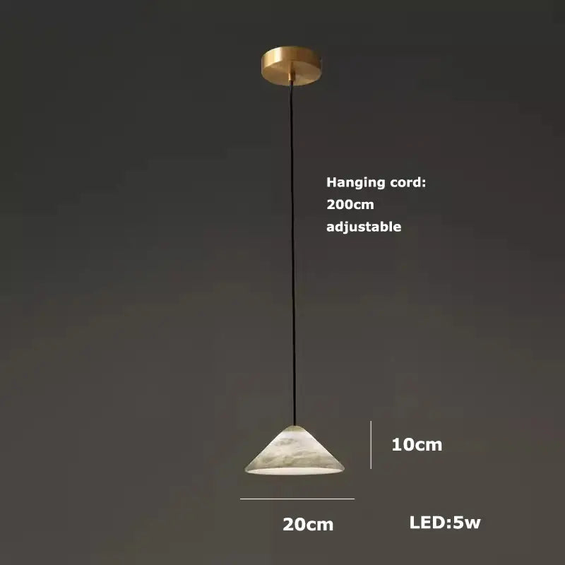 A modern alabaster pendant light with gold ceiling mount, black cord, and frosted white glass shade for living room