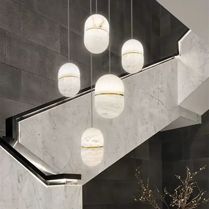 Elegant white marble alabaster pendant lights with gold accents in a modern chandelier for living room decor