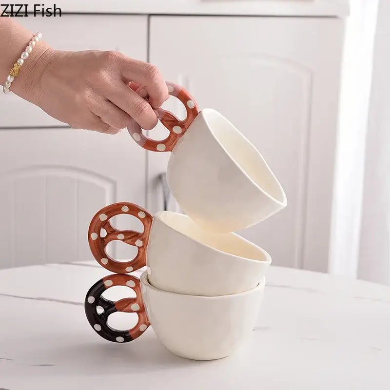 White ceramic biscuit mug ceramic with pretzel-shaped brown and black handles and white polka dots by decorbites alkali water biscuit