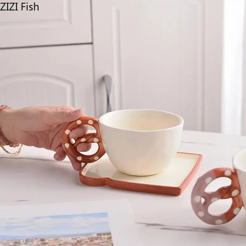 Decorbites alkali water biscuit mug ceramic teacup with white body and orange polka dot pretzel handle on matching saucer