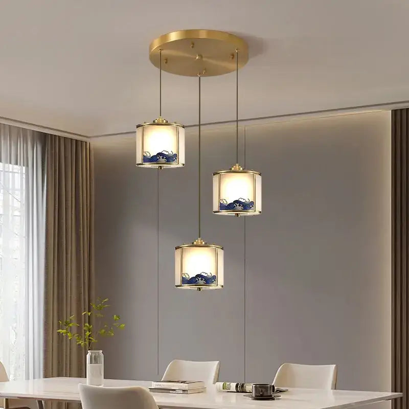 Three elegant pendant lights with gold-toned copper frames and blue wave glass shades for rotating staircase light