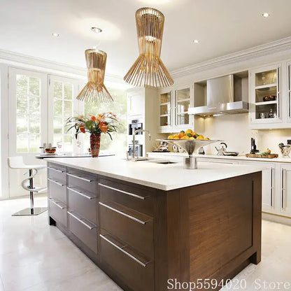 Modern wooden kitchen island with sleek white countertop and brushed metal drawer handles illuminated by allegro iron pendant lights