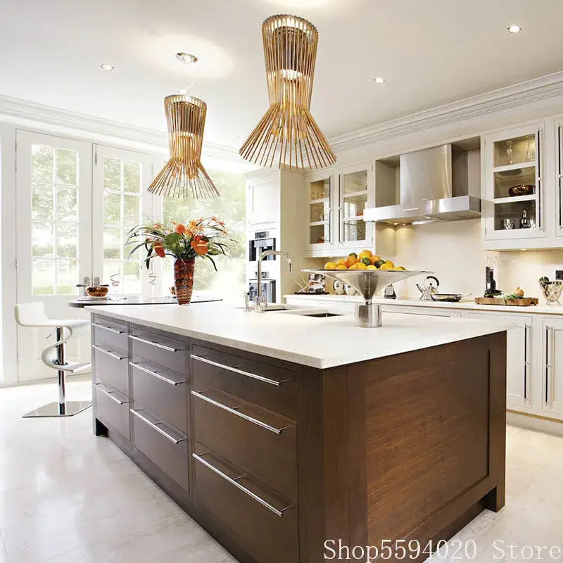 Modern wooden kitchen island with sleek white countertop and brushed metal drawer handles illuminated by allegro iron pendant lights