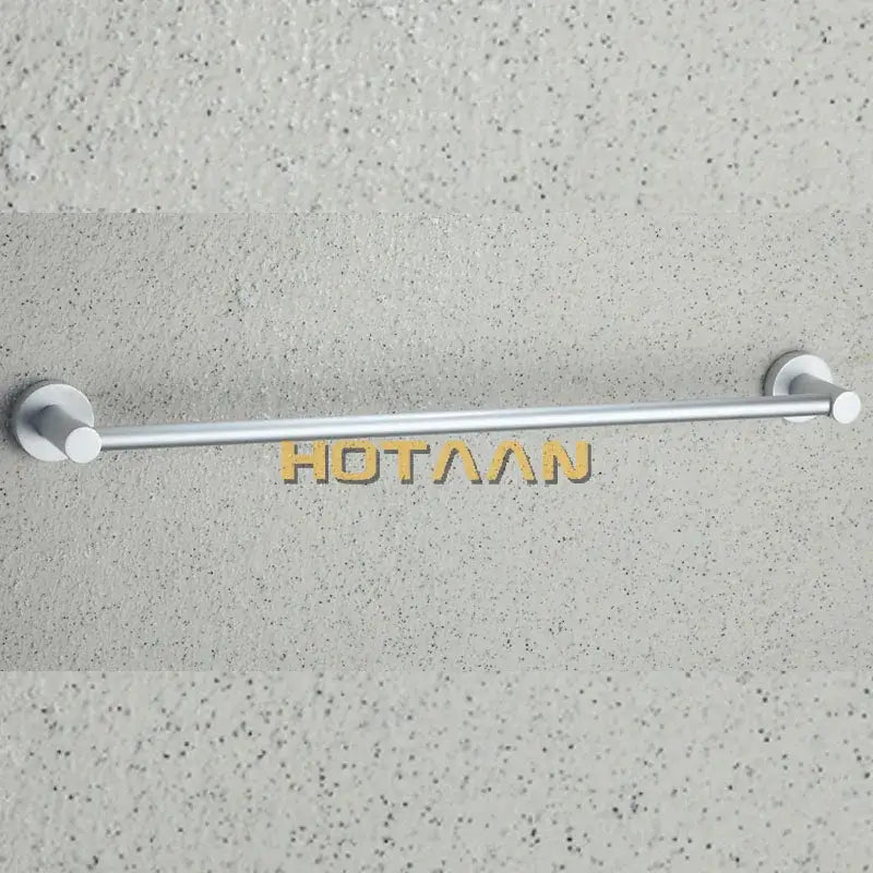 Silver-toned aluminium towel bar rail holder with sleek minimalist circular end caps mounted on textured wall