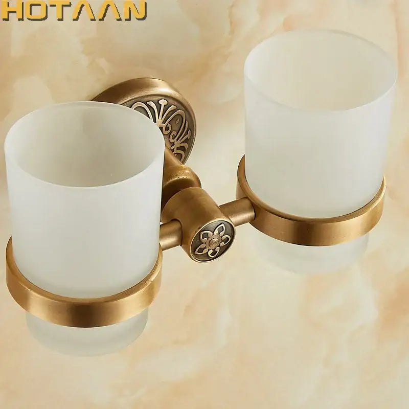Decorbites aluminium double tumbler holder in antique brass finish with frosted glass cups and ornate floral detailing