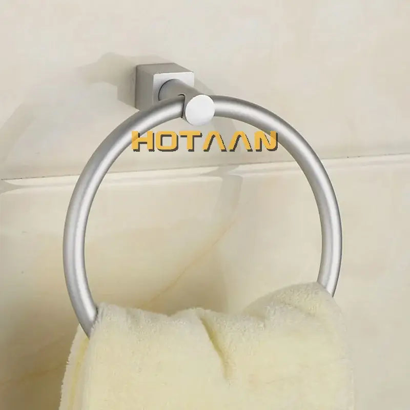 Silver-toned aluminium round towel holder ring with square base holding a cream towel for bathroom use