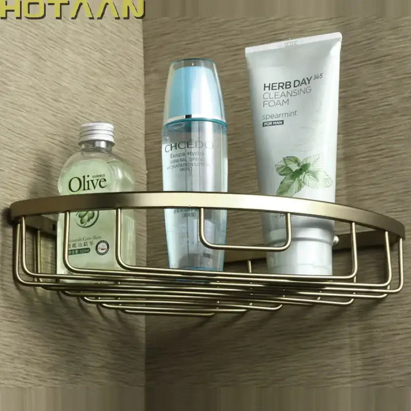 Gold-toned aluminum DecorBites™ single layer shower basket holder shelf holding toiletries in a corner shower