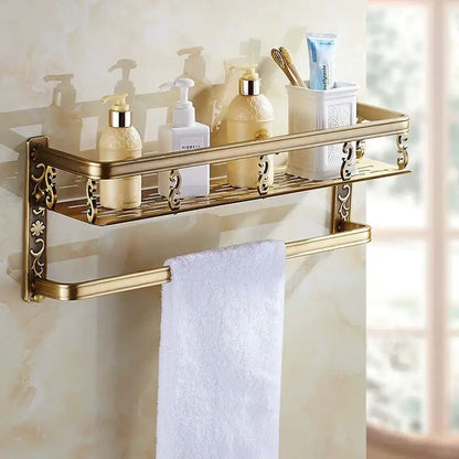 Gold-toned aluminum DecorBites™ bathroom corner shelf with ornate floral detailing holding toiletries and a matching towel bar