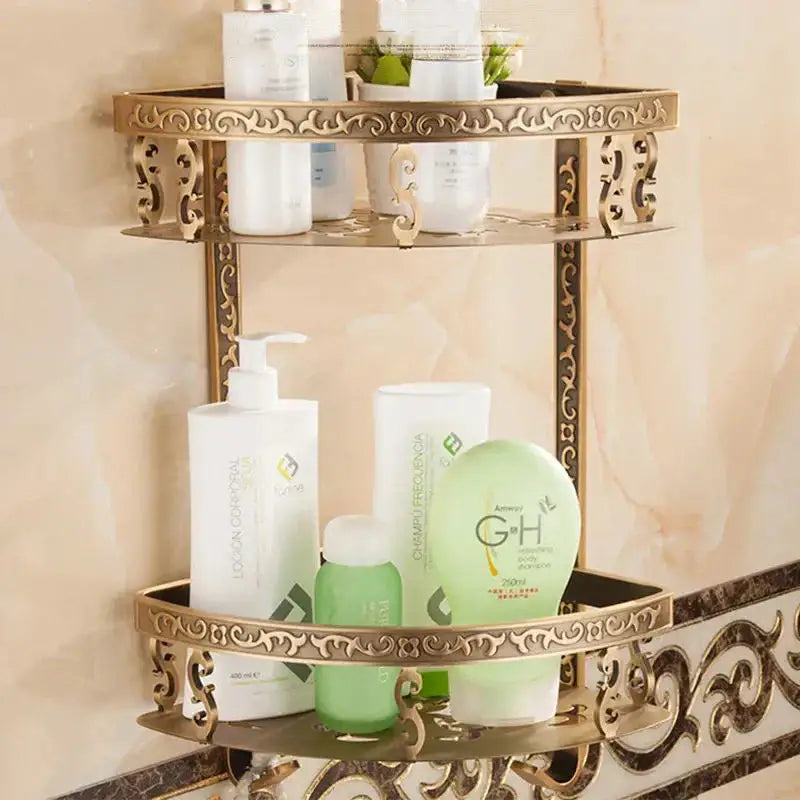 Ornate gold-finished aluminum two-tiered bathroom corner shelf with intricate scrollwork for shower room storage