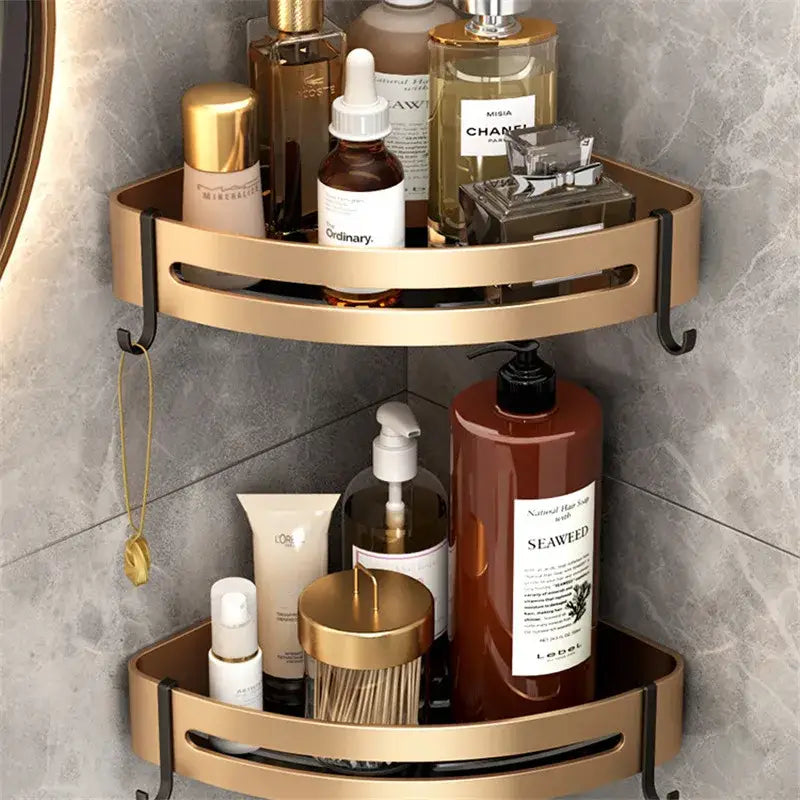 Gold-toned aluminum bathroom corner shelf with double-tier design and black mounting hooks for shower storage