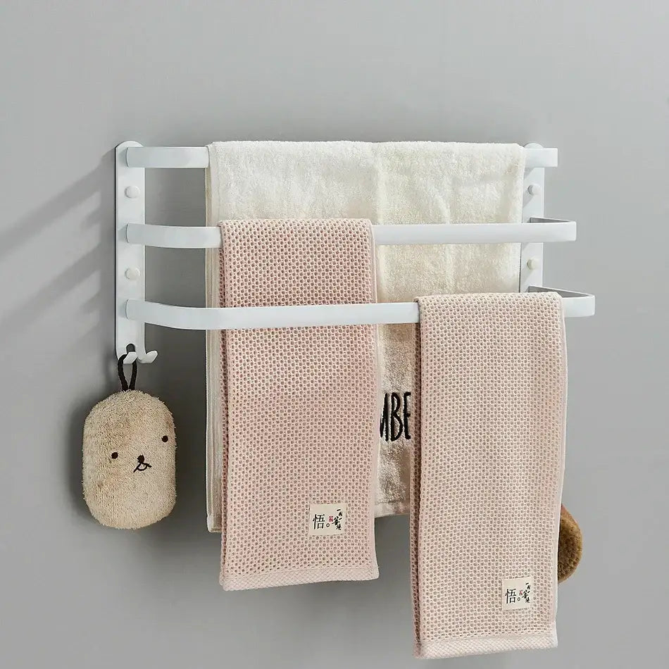 White wall-mounted aluminum bathroom towel rack with multiple layers holding three towels and a hanging bath sponge