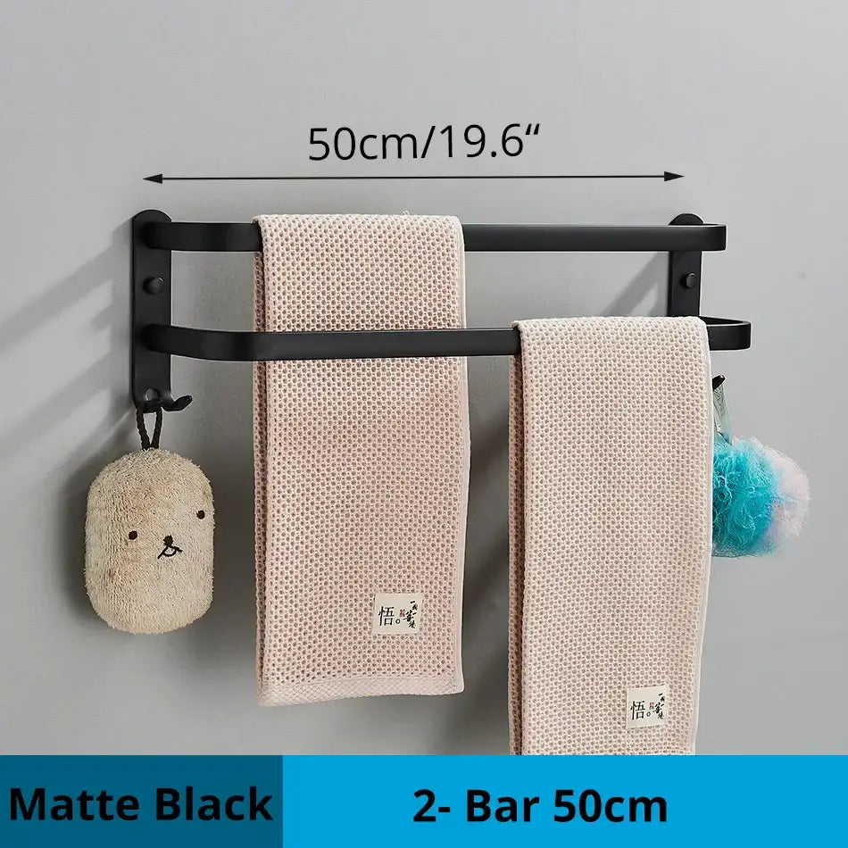 Matte black decorbites aluminum bathroom towel rack with double bars holding two beige textured towels wall mounted