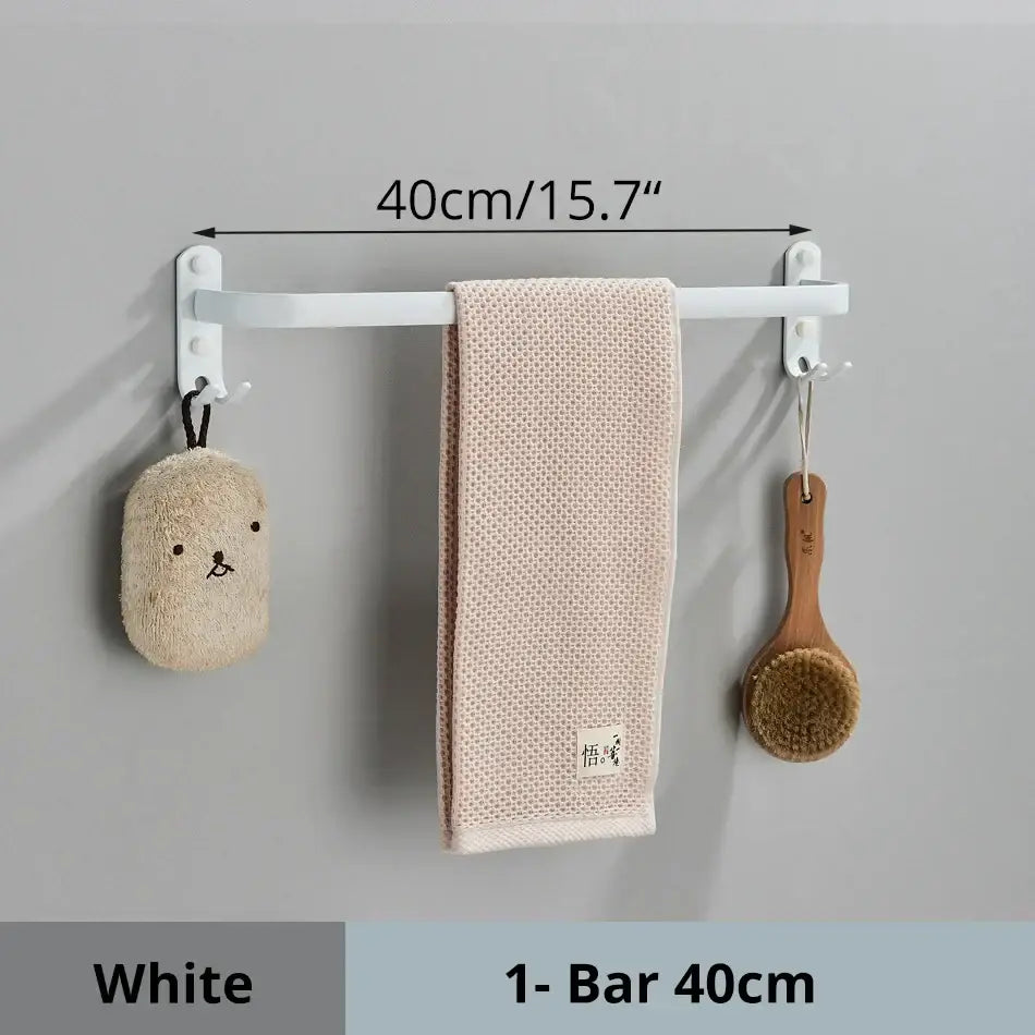 Decorbites aluminum bathroom towel rack in white holding a beige towel and two hanging bath accessories