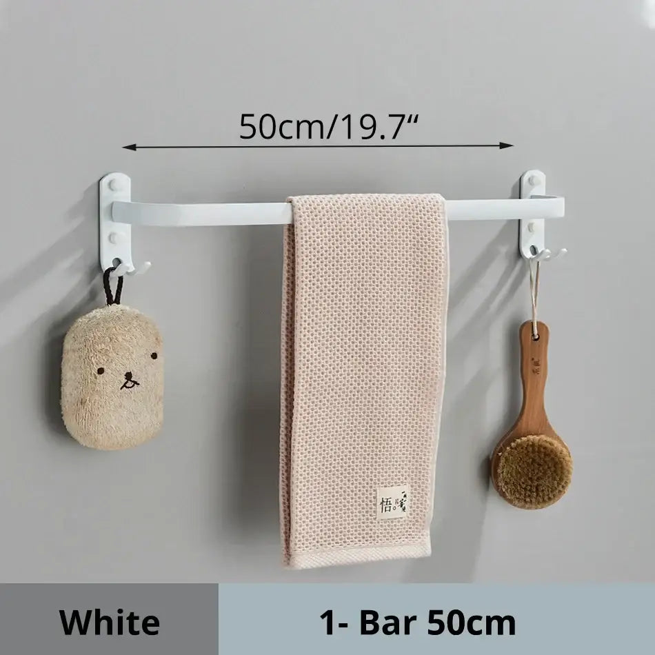 White aluminum bathroom towel rack with two hooks holding beige textured towel and decorative items wall mounted