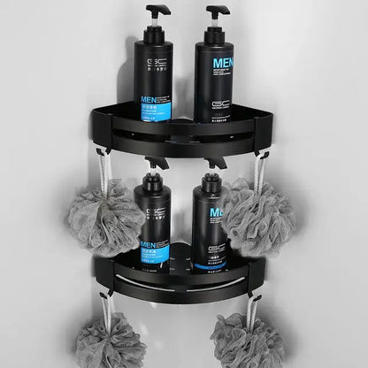 Black two-tier aluminum corner shower caddy with four pump bottles and gray loofahs in decorbites bathroom hardware set