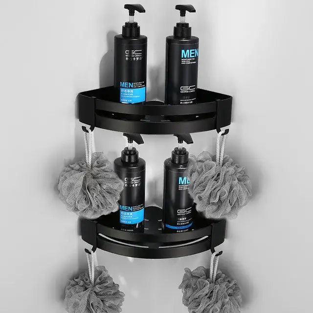 Black two-tier aluminum corner shower caddy with four pump bottles and gray loofahs in decorbites bathroom hardware set