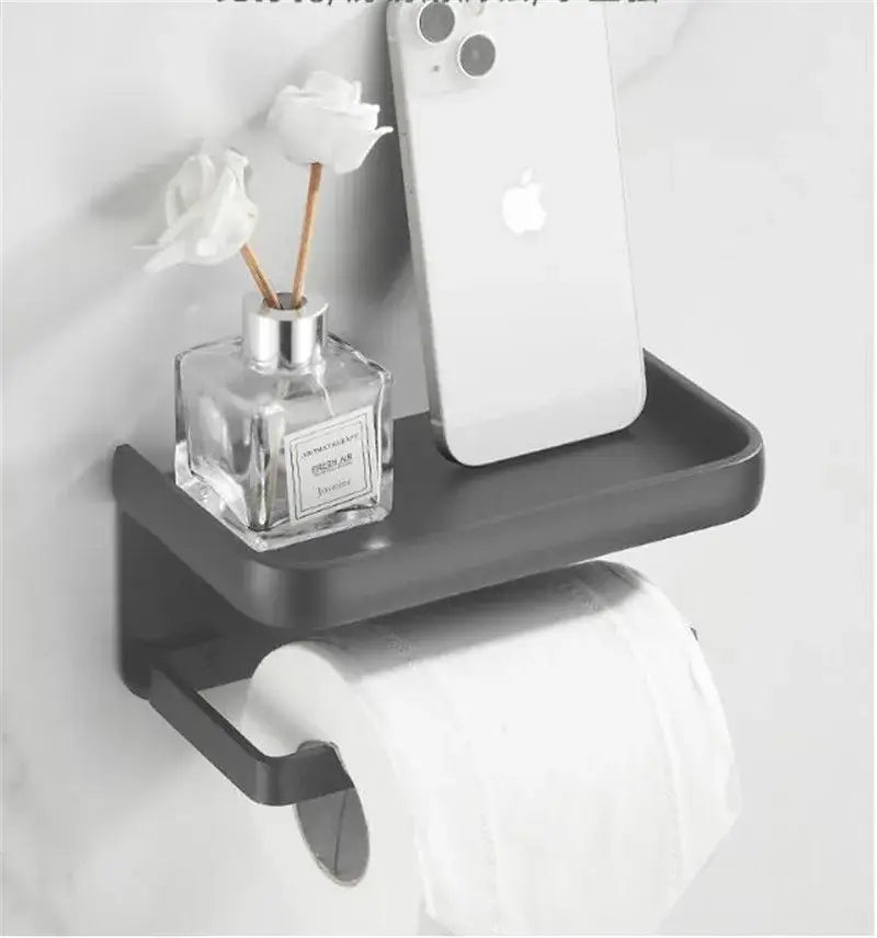 Black matte aluminum DecorBites tissue holder with phone shelf wall-mounted for toilet paper storage and convenience