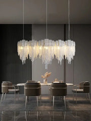 A modern aluminum chain pendant light with cascading translucent glass prisms for dining table lighting